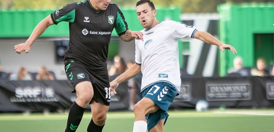 Two players competing for the ball in football match