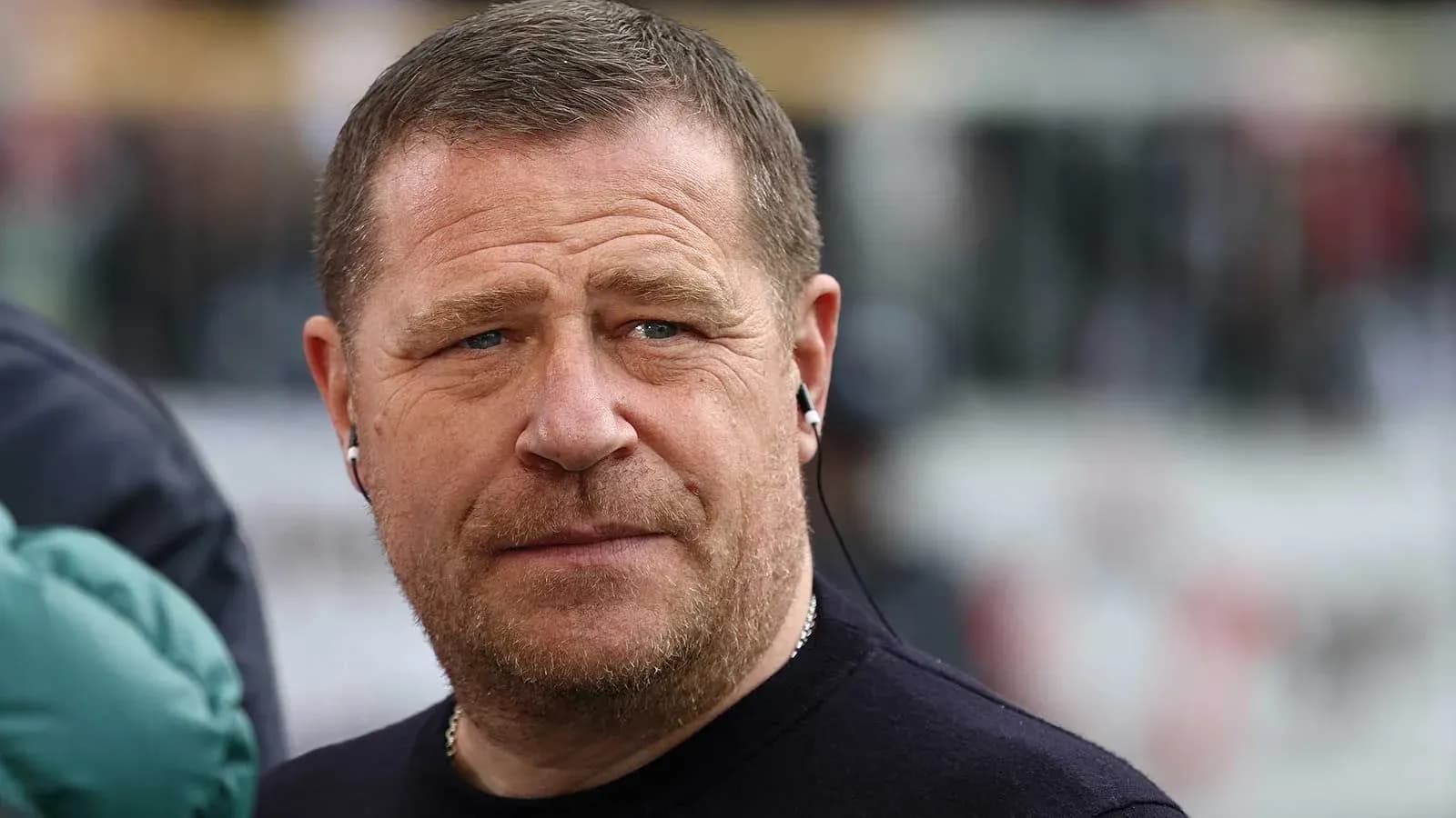 Person wearing earbuds, looking serious outdoors