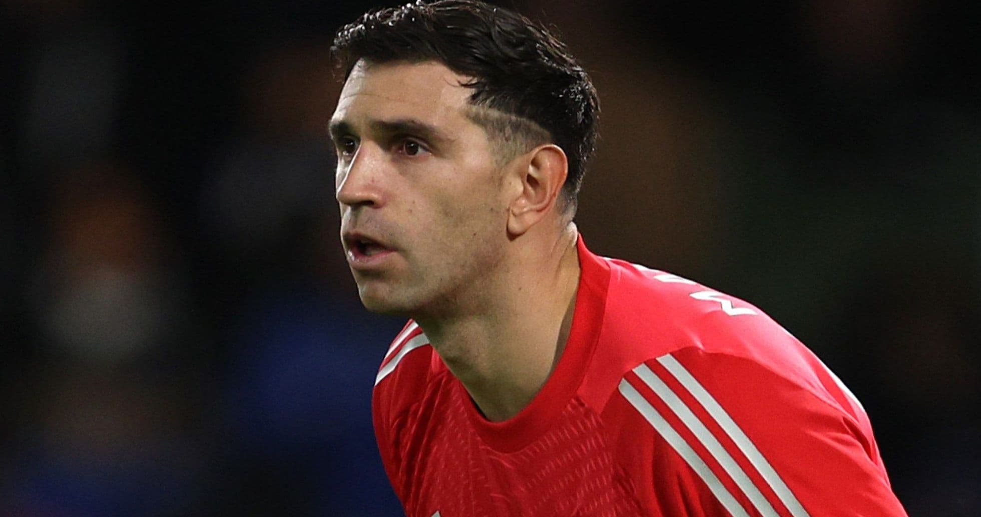 Goalkeeper in red kit focused on play