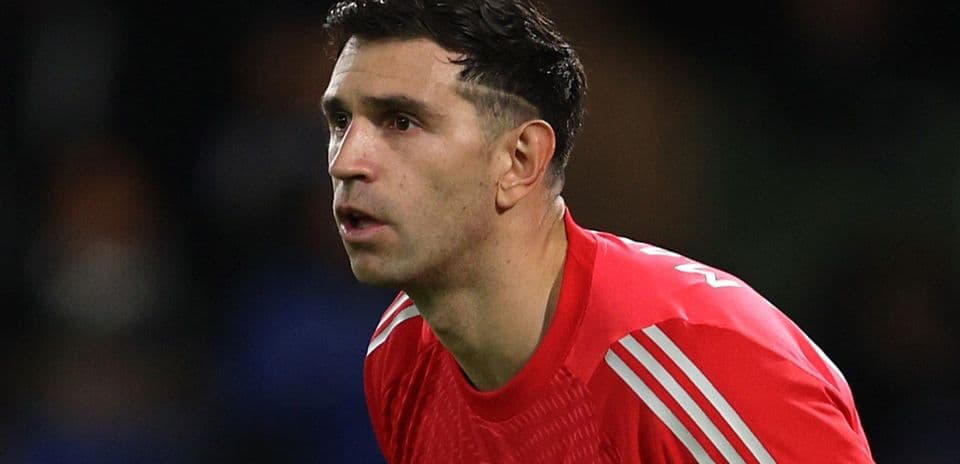 Goalkeeper in red kit focused on play
