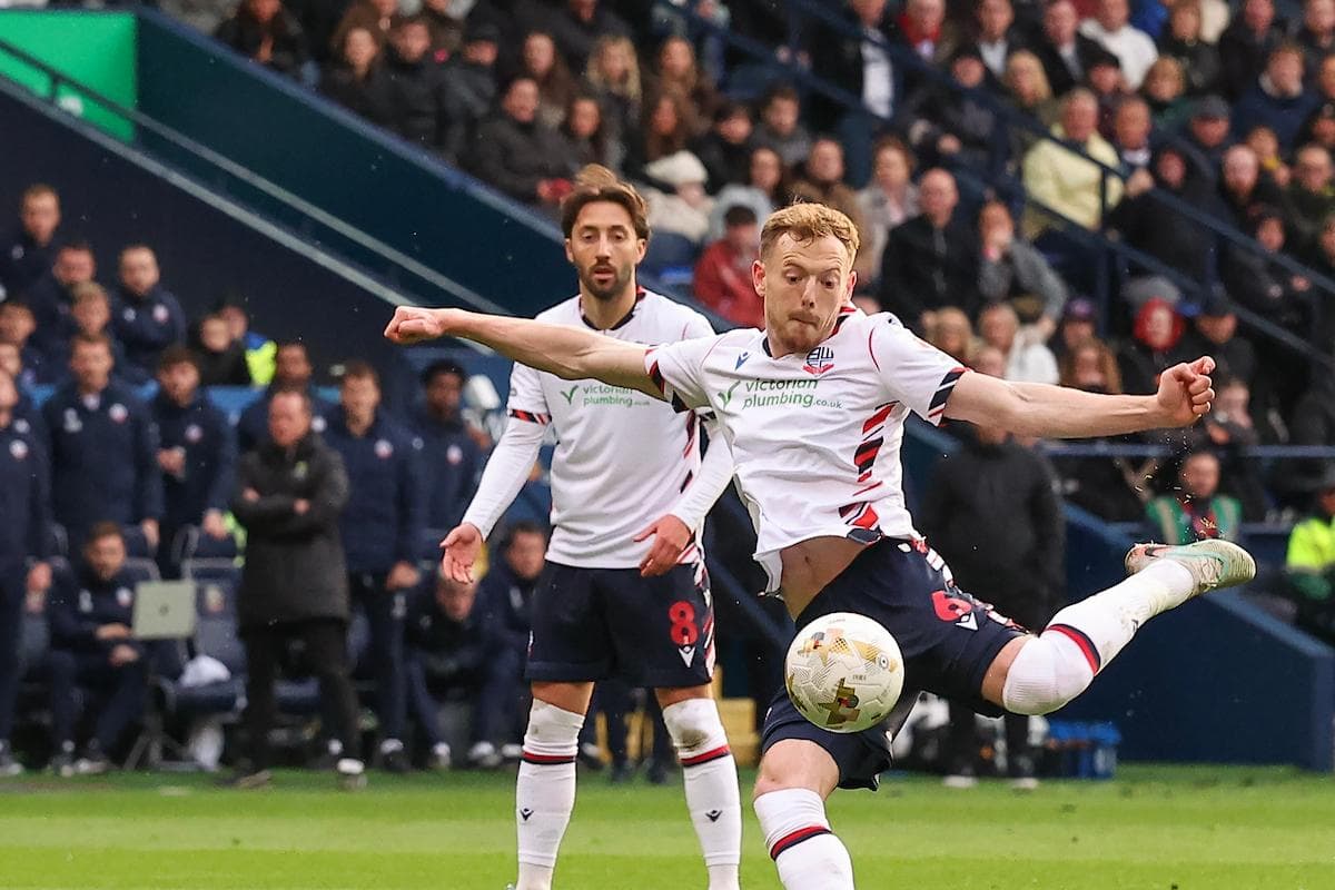 Bolton player striking ball during match action
