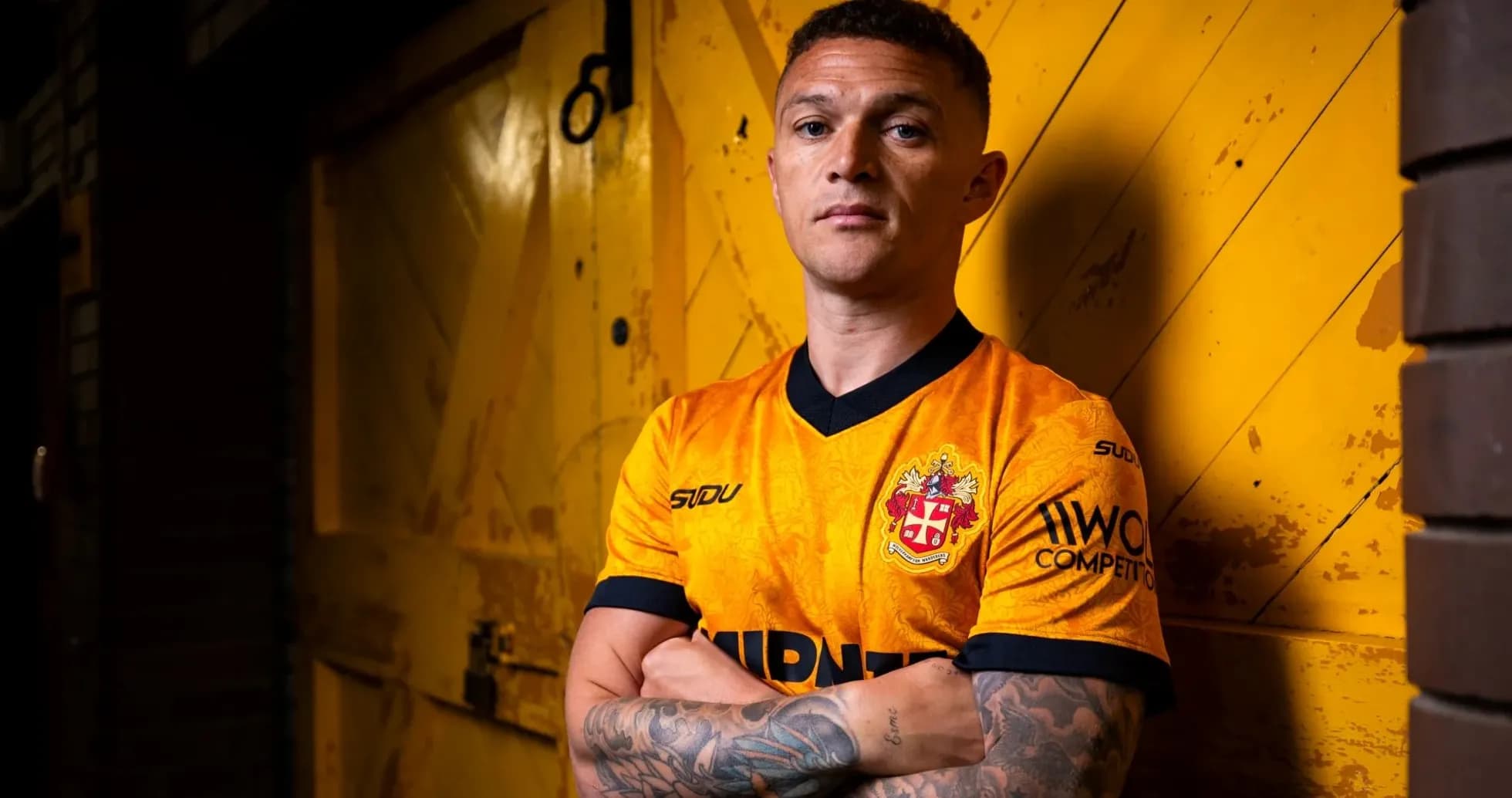 Player posing in orange jersey against yellow background