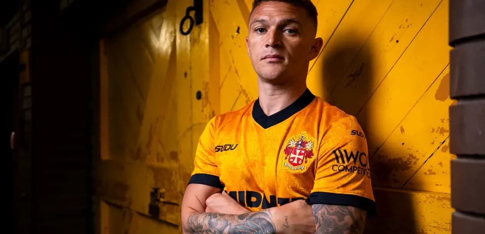 Player posing in orange jersey against yellow background