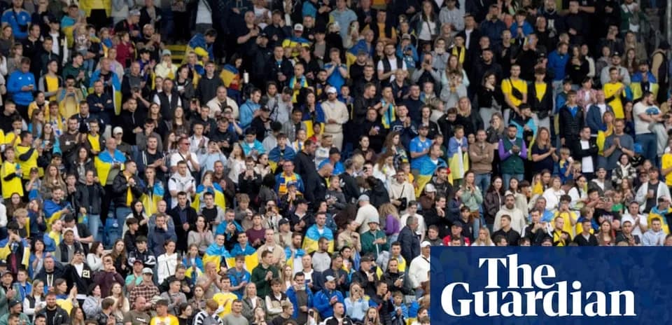 Crowd of fans in stadium with yellow and blue attire