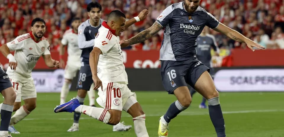 Sevilla player tackling Real Sociedad opponent