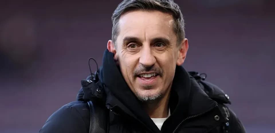 Man smiling in black jacket at stadium