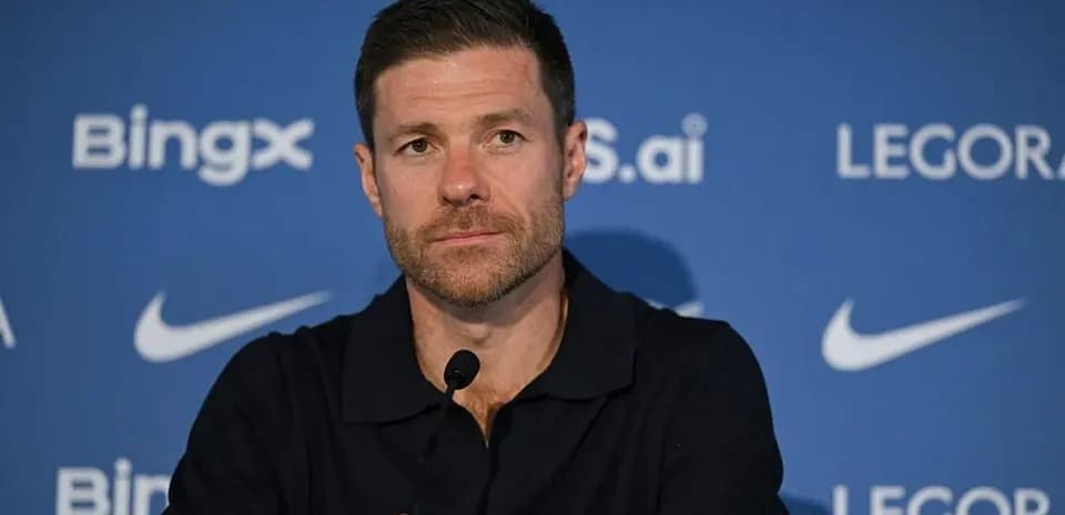 Manager speaking at press conference with branding backdrop