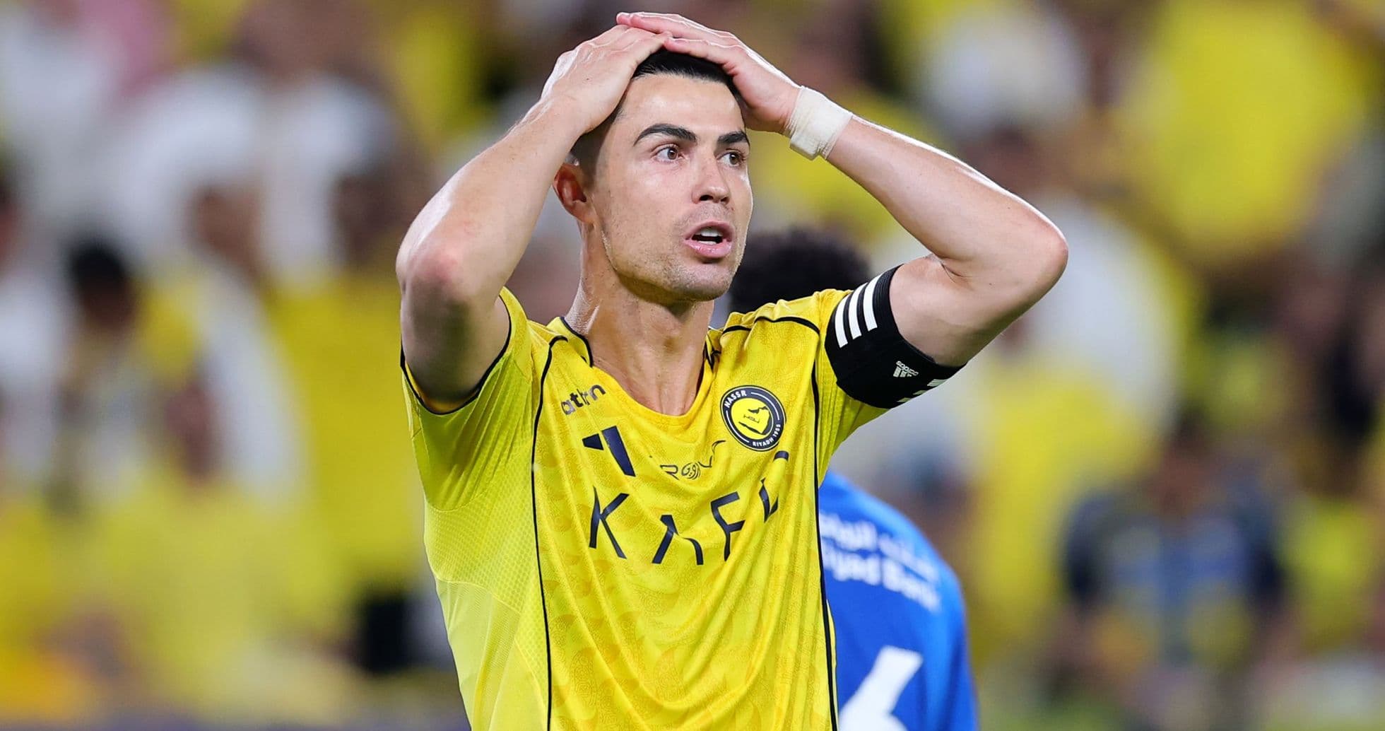 Player in yellow jersey with hands on head