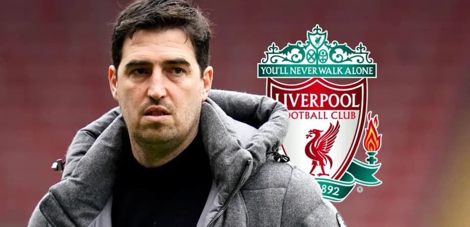 Coach in front of Liverpool FC logo during match