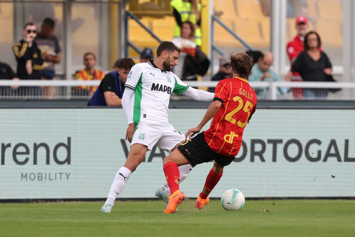Sassuolo player challenging Lecce opponent for ball