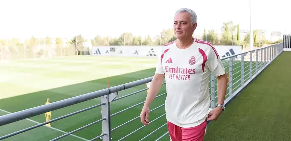 Coach walking along training pitch at facility