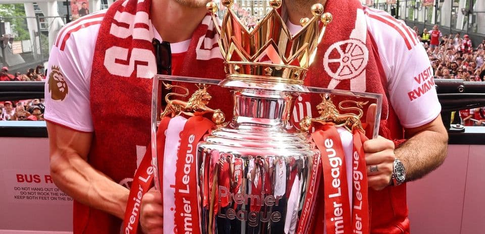 Players celebrating with Premier League trophy at parade