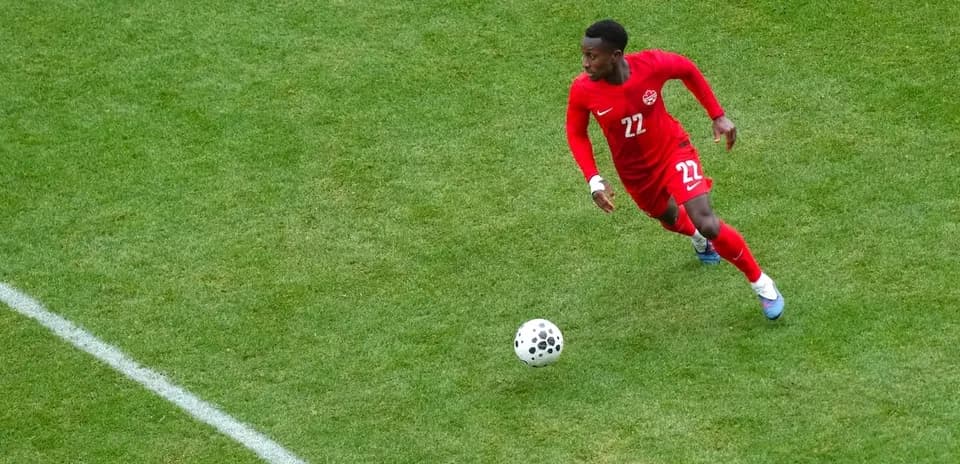 Canadian player dribbling ball on the field