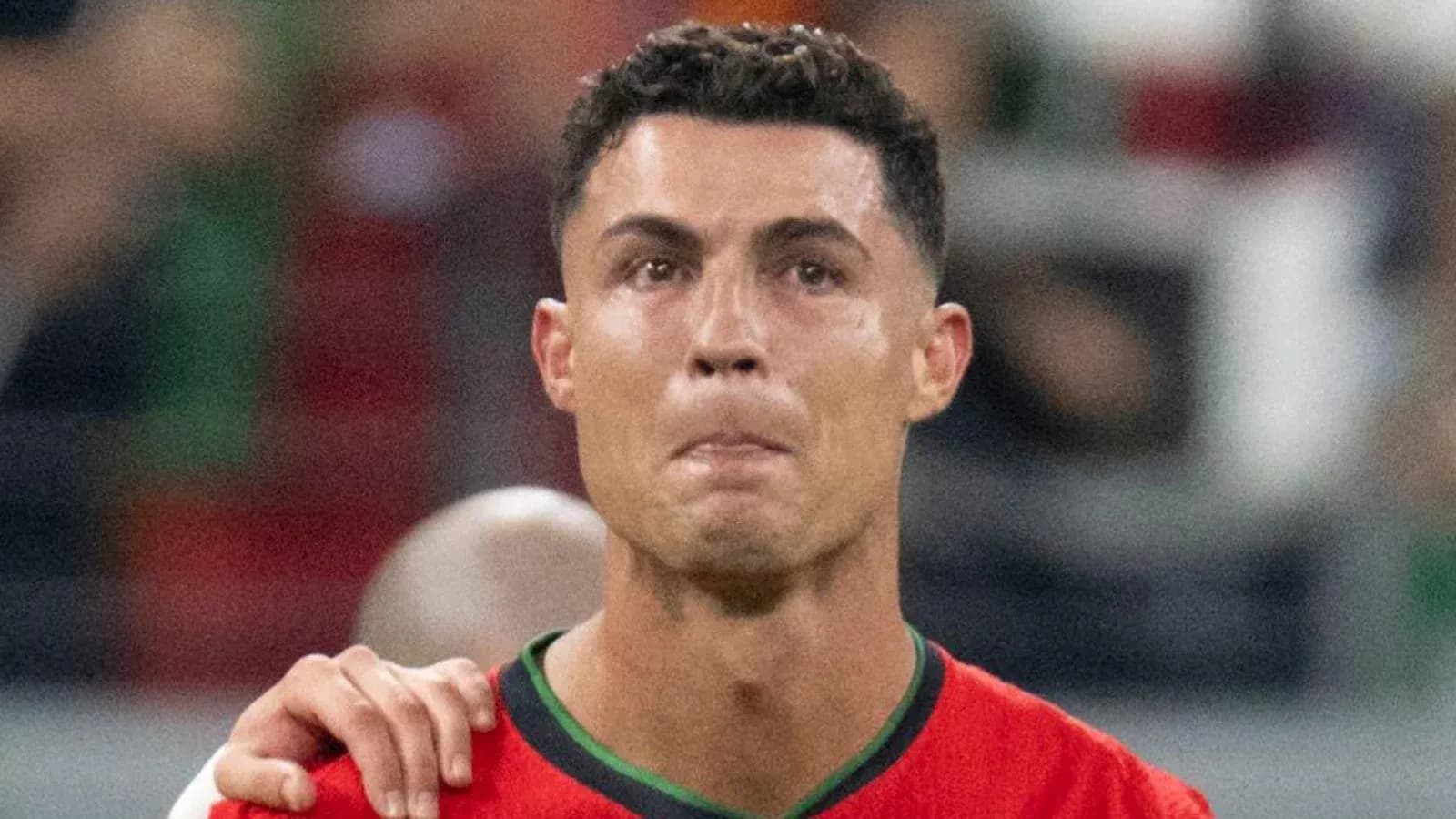 Player wearing red jersey during match celebration