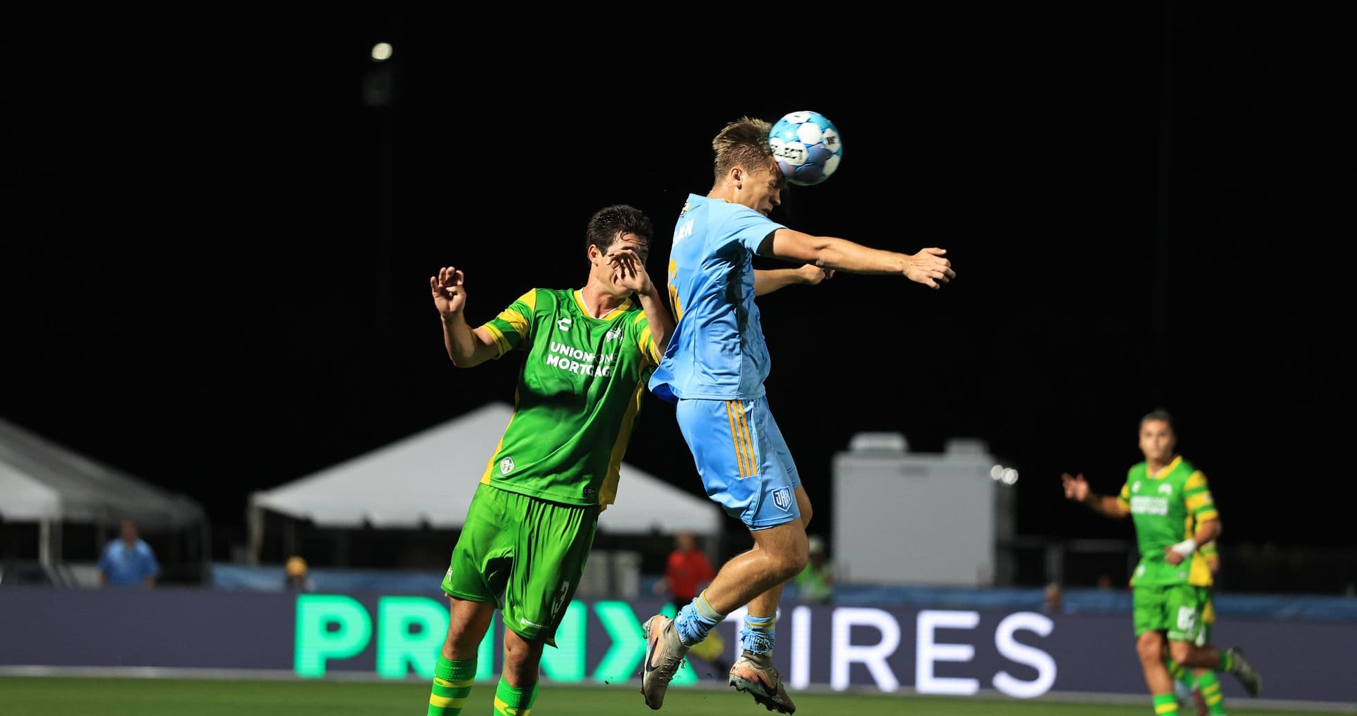 Players contesting a header during match