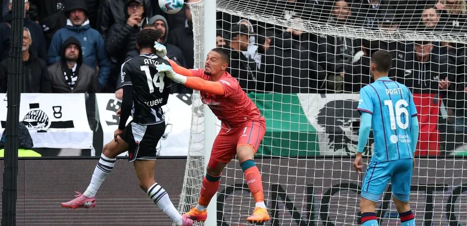 Goalkeeper defending against shot during match