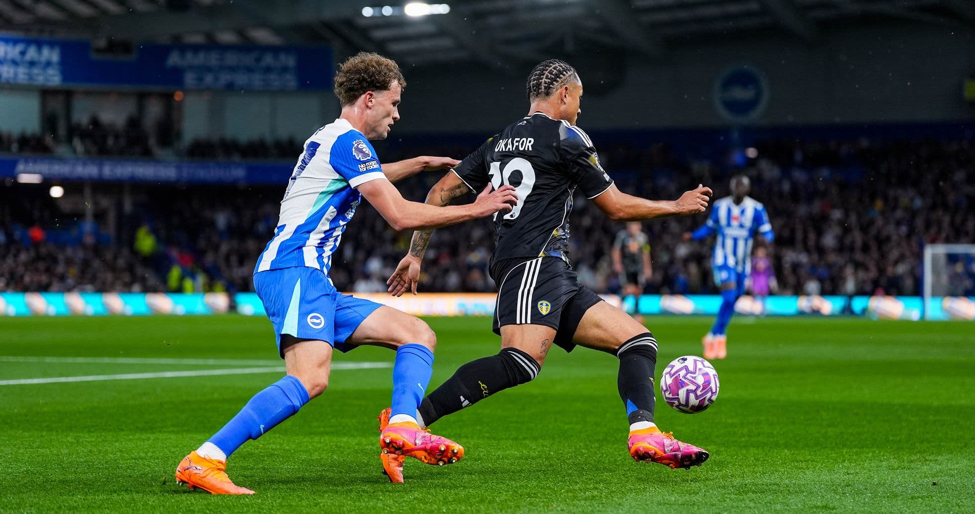 Leeds player challenged by Brighton defender during match
