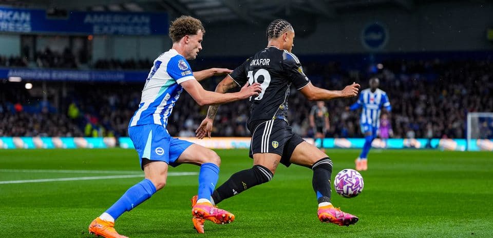 Leeds player challenged by Brighton defender during match