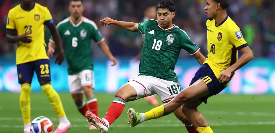 Mexico player challenges Ecuador player for ball