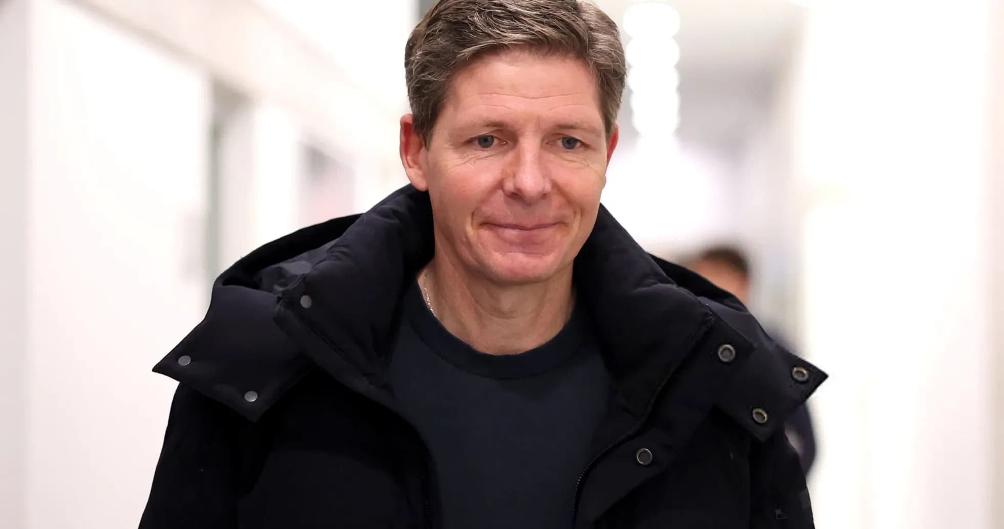 Man walking in a corridor wearing a dark jacket