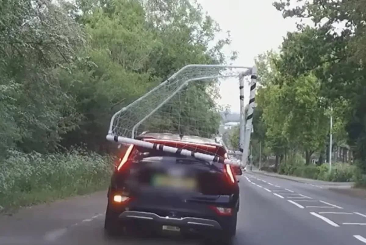 Car transporting a soccer goal on a road