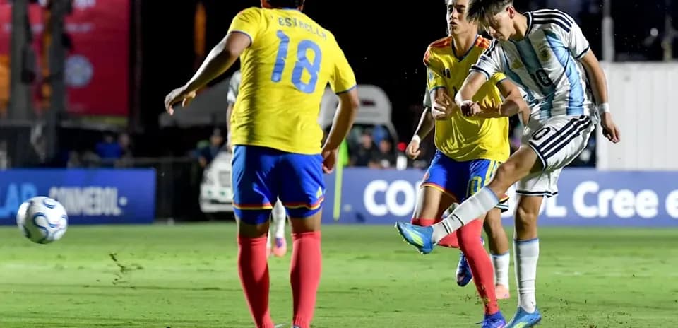 Argentinian player kicking ball against Ecuadorian defenders