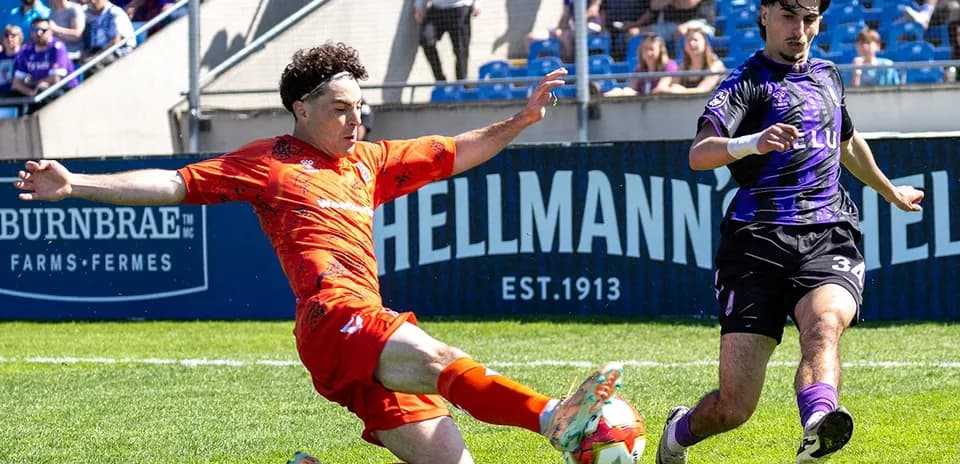 Player sliding tackle during Forge vs Pacific FC match