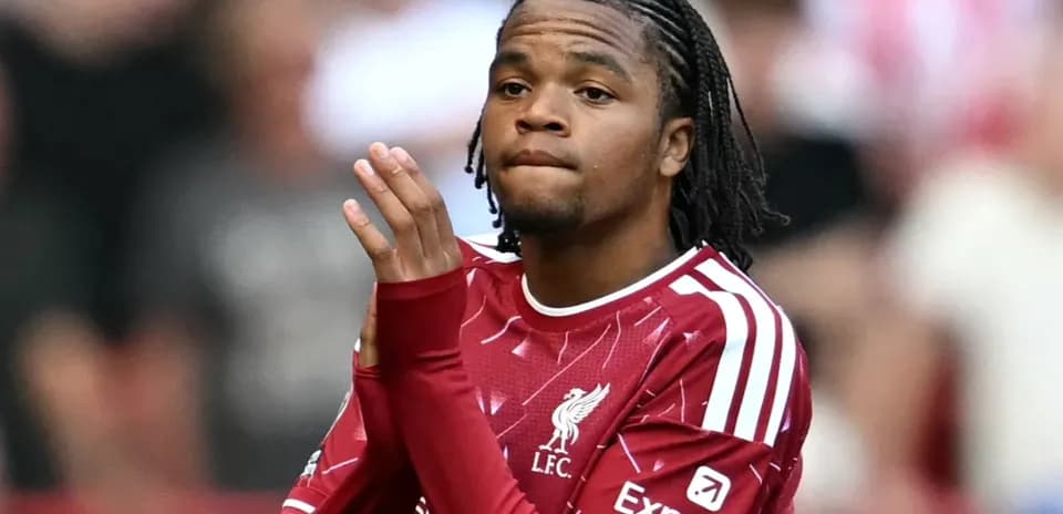 Player in Liverpool kit applauding fans at match