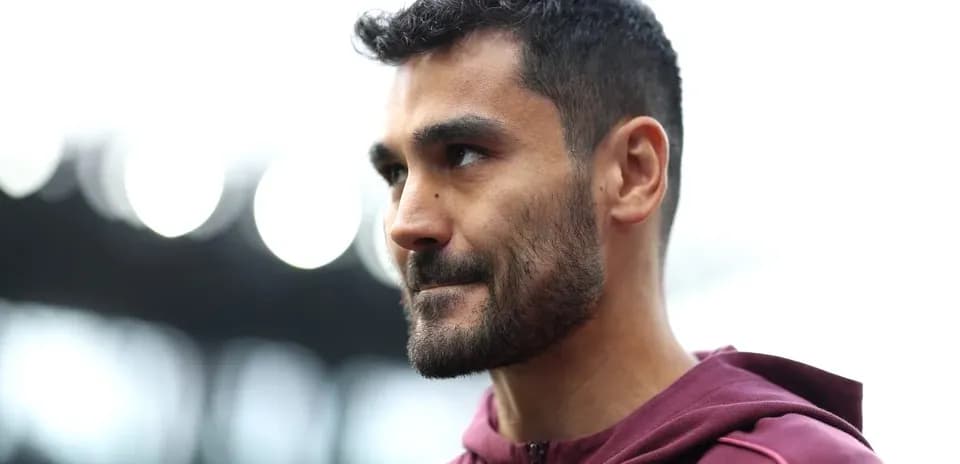 Football player in maroon jacket during training session