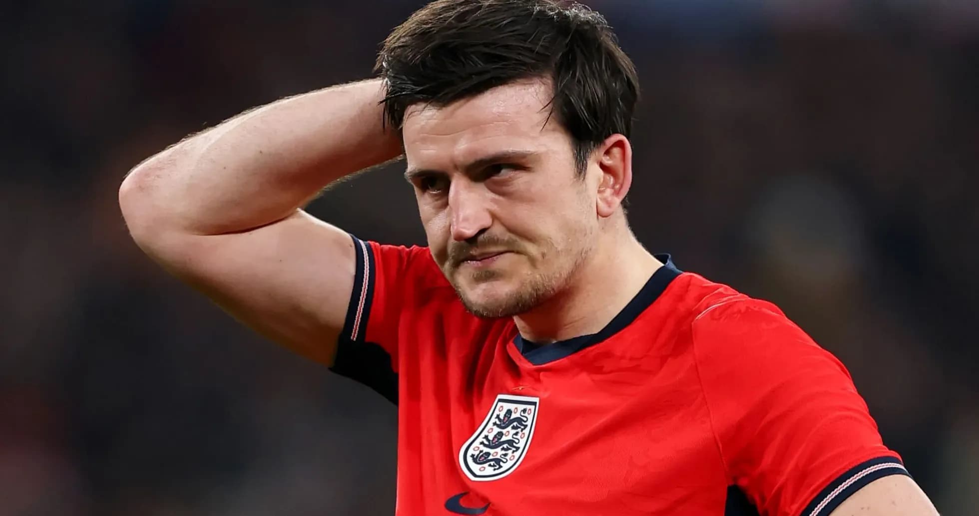 Player in red jersey with England crest looking concerned
