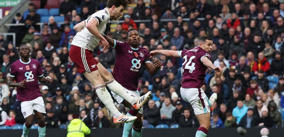Arsenal player jumping to head the ball