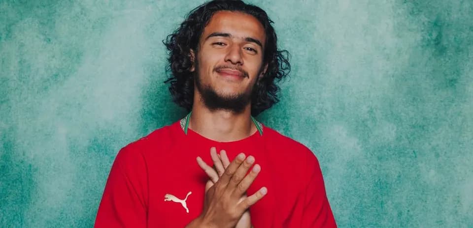Player posing in red jersey with hands together