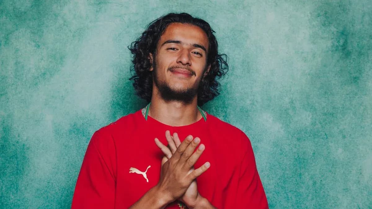 Player posing in red jersey with hands together