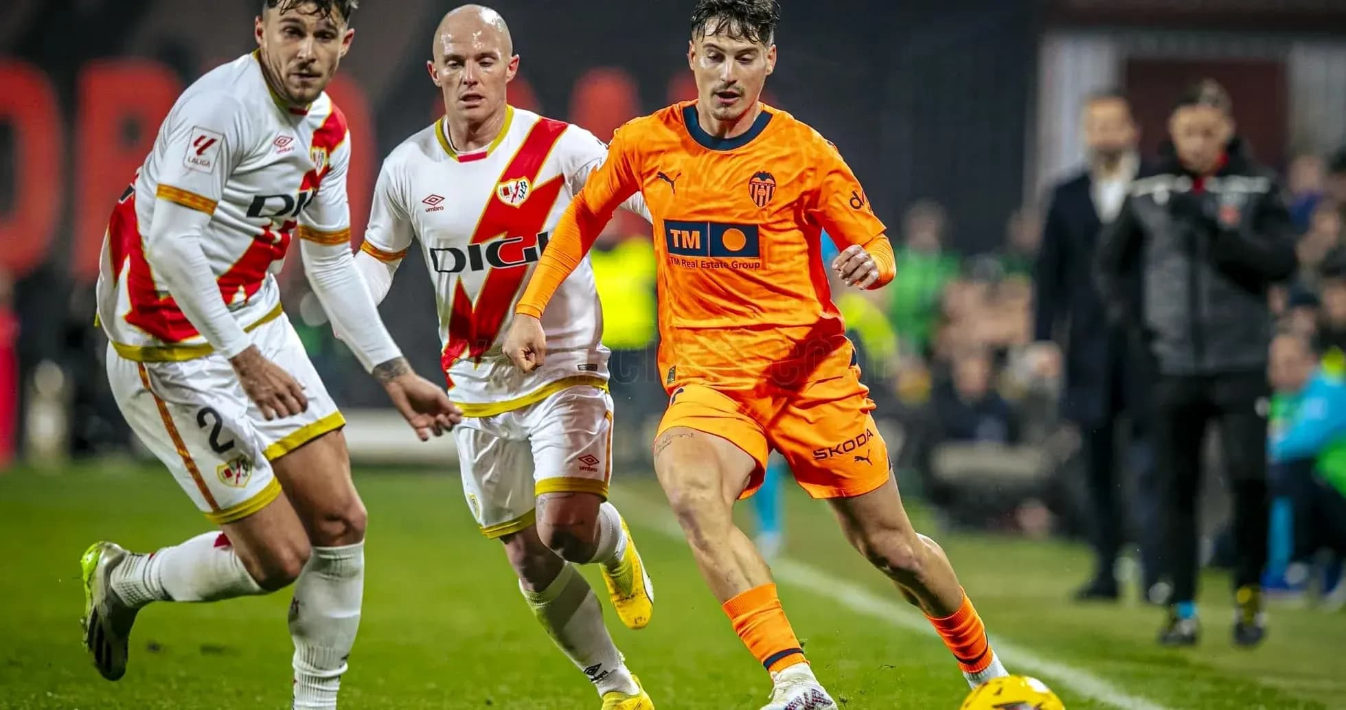 Valencia player dribbling past Rayo Vallecano defenders