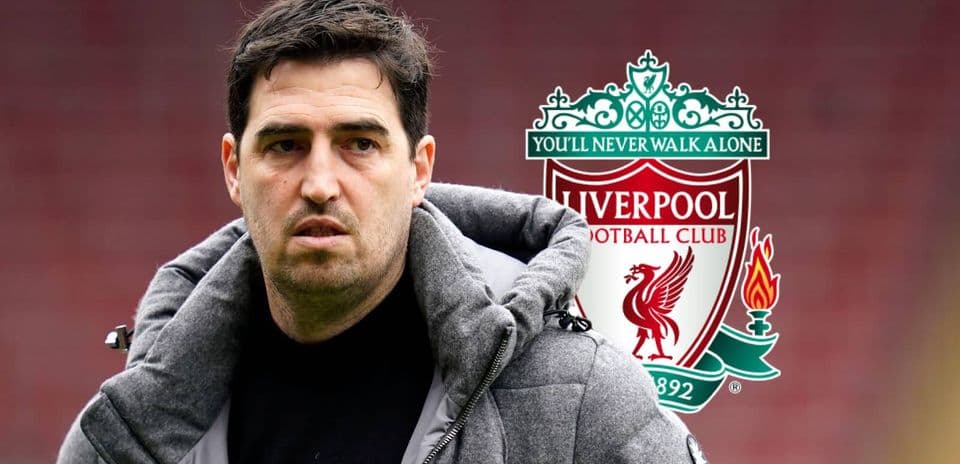 Coach in front of Liverpool FC logo backdrop