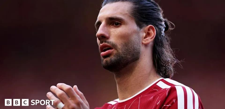 Player in red jersey looking focused before match