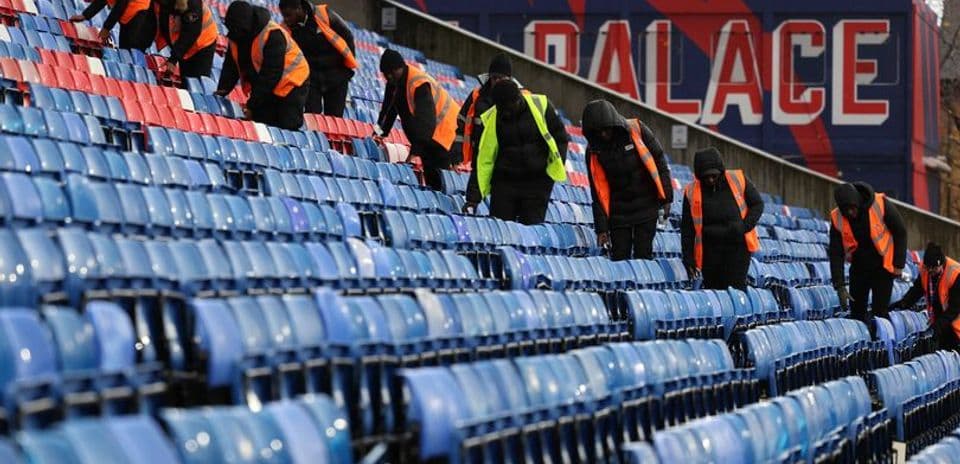 Staff preparing empty stadium seats for event