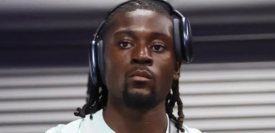 Athlete wearing headphones, walking in a corridor