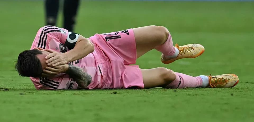 Player on the ground, holding face in distress
