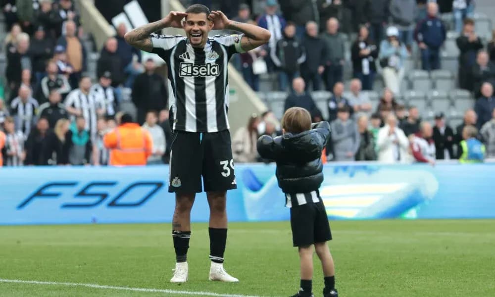 Newcastle player celebrating with a child on pitch
