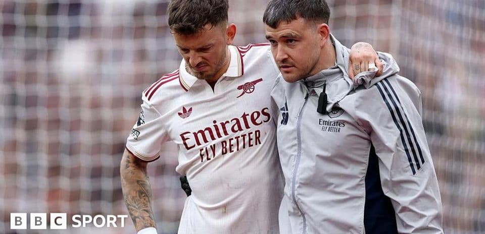 Player being assisted off the pitch by staff