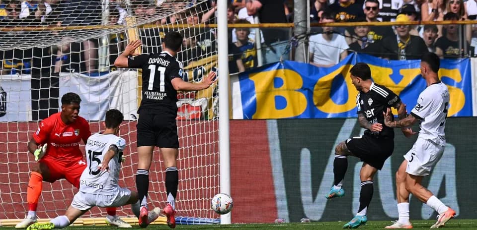 Como player shooting at goal against Parma