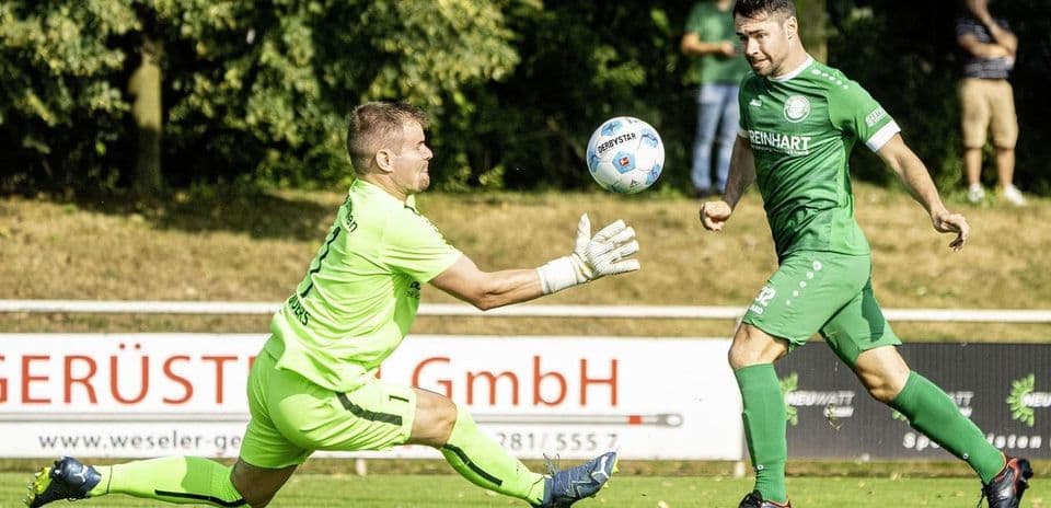 Goalkeeper attempting to catch the ball during match