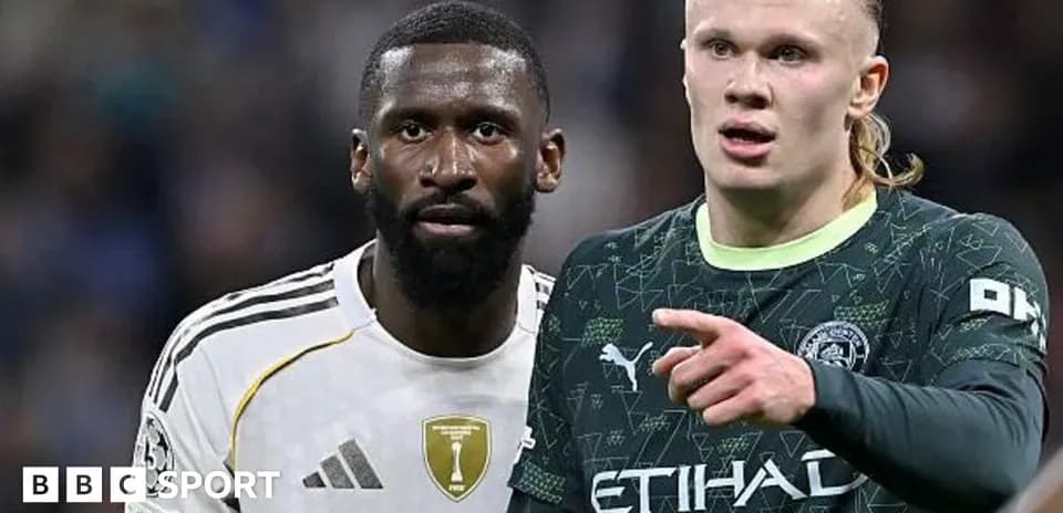 Two football players in competitive stance on pitch