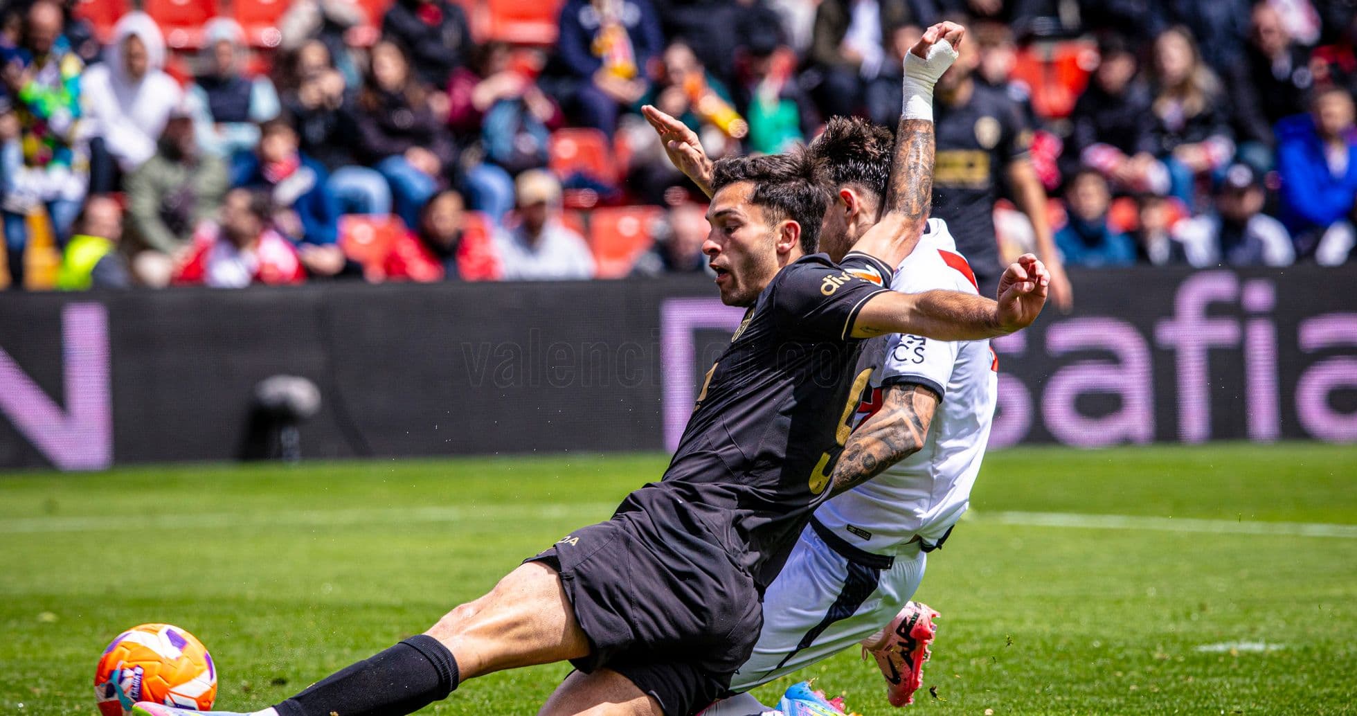 Player tackling opponent during Valencia match