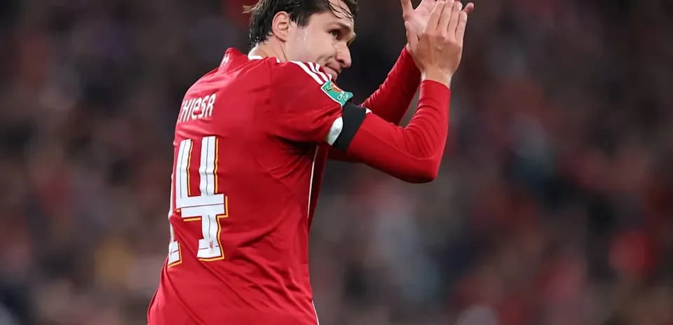Player applauding fans during match in red jersey