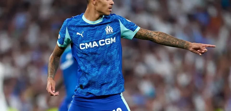 Player in Marseille kit directing teammates on field