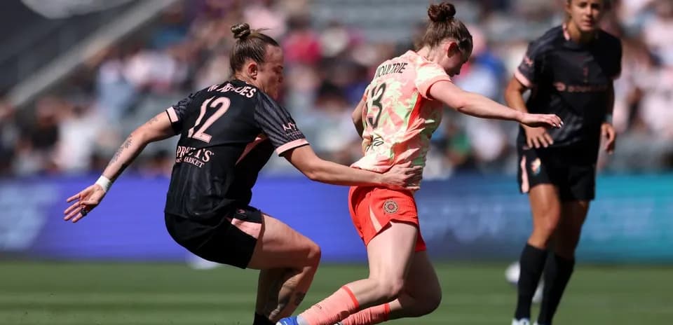 Player tackles opponent during NWSL match