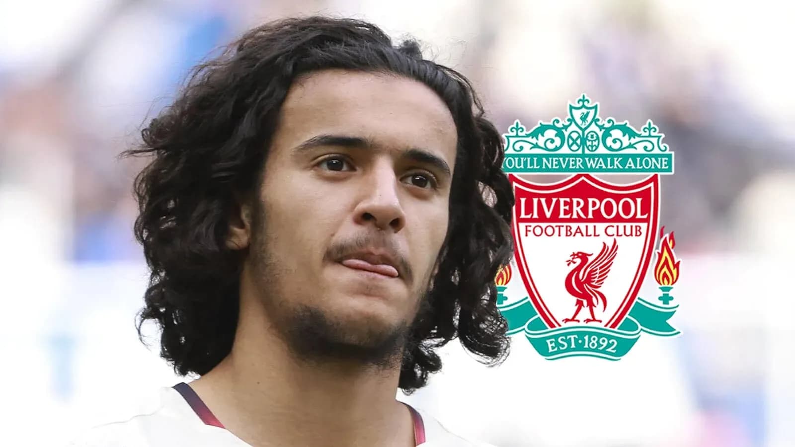 Player with curly hair next to Liverpool FC logo