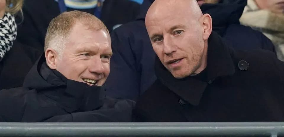 Two men talking in the stands at a game